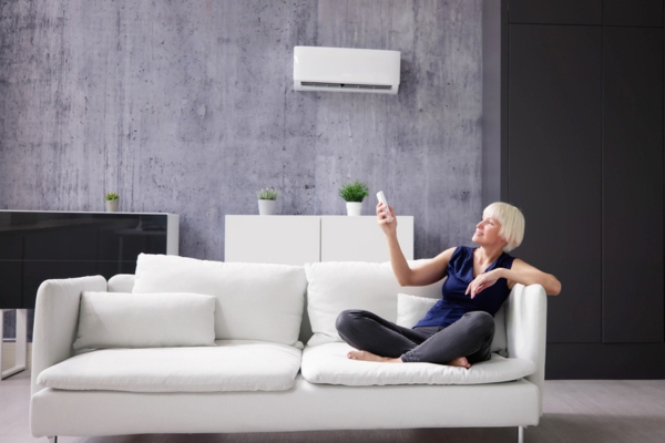 woman turning on ductless air conditioner