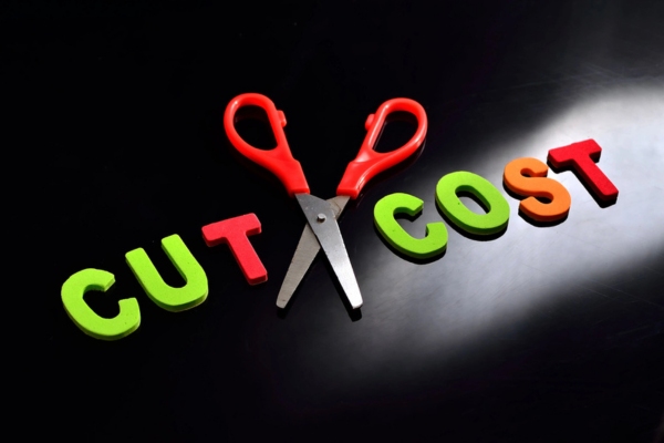 Scissors and the alphabet that says CUT COST depicting reduced heating oil costs