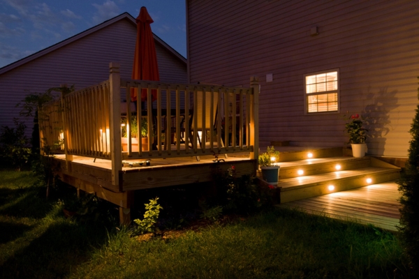 Wooden deck and patio of family home at night
