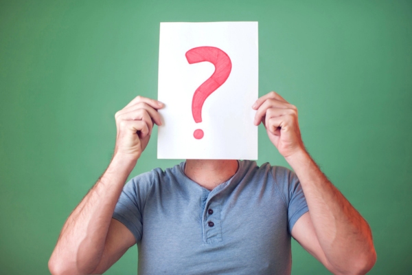 man holding question mark sign on his face depicting FAQs about sewer gas smell in house