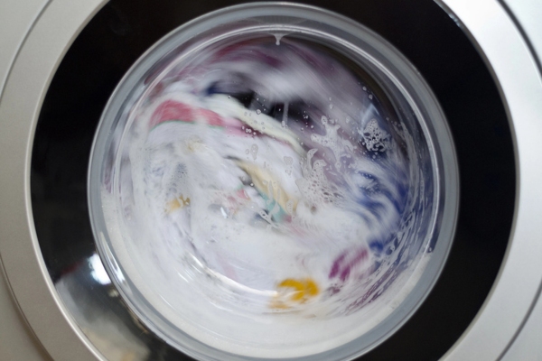 Washing machine door with rotating garments inside