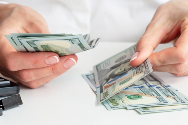 cropped view of a woman's hands counting money depicting Upfront HVAC Cost Range