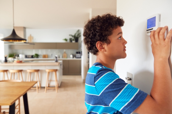 kid fidgeting with home thermostat