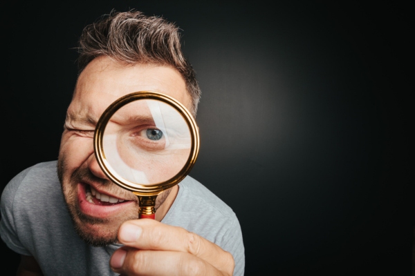 man looking through a magnifying glass depicting Closer Look at Renewable Energy Sources