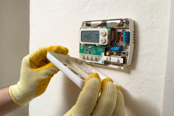 technician examining home thermostat