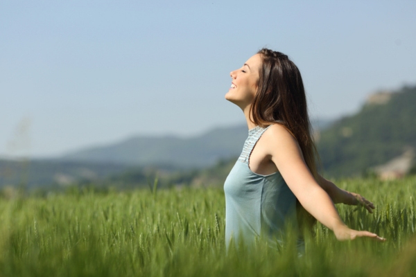 woman breathing fresh air outdoors depicting Bioheat® Heating Oil Helps Cut Pollution