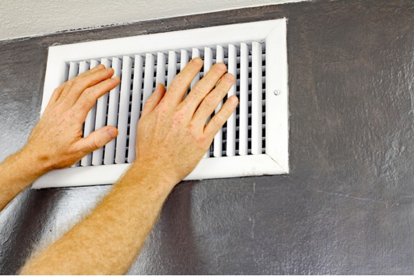 homeowner checking home HVAC vent