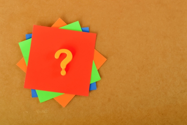 question mark on top of a stack of colored papers depicting FAQs about Clogged Toilet