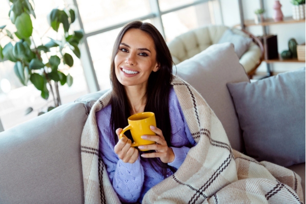 woman feeling warm and cozy while having coffee during winter