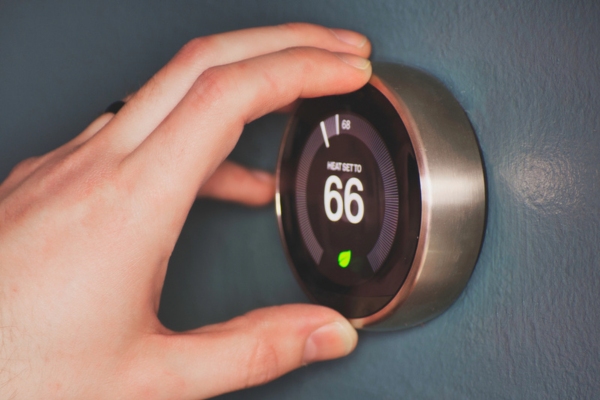 homeowner operating smart thermostat