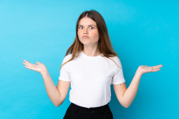 young woman shrugging with hands on the side asking What Are Power Surges