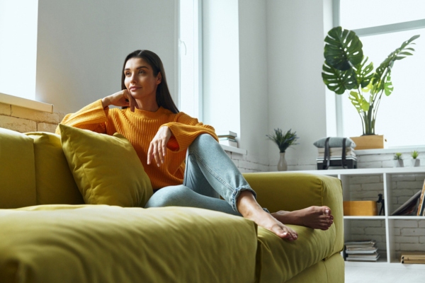 woman lounging on the couch feeling reassured with reliable heating oil performance