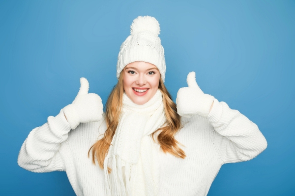 woman in full winter outfit with both her thumbs up depicting Improved Coordination and Seasonal Readiness