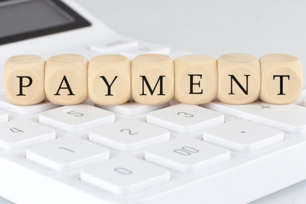 Wooden cubes with text PAYMENT on calculator