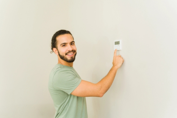 homeowner adjusting smart thermostat at home