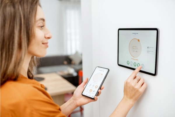 homeowner synching smart thermostat to a smart phone