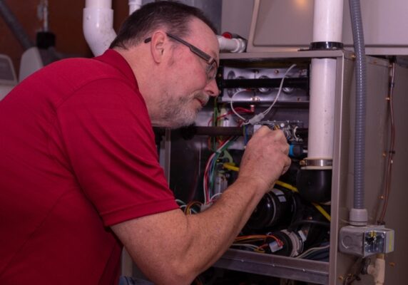 HVAC technician troubleshooting a furnace