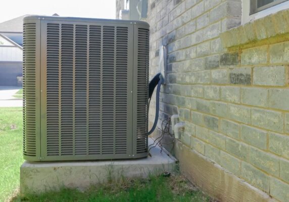 air conditioner system installed against a brick wall