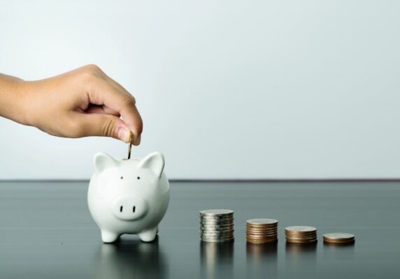 coin being dropped inside piggy bank depicting energy savings modern air conditioners