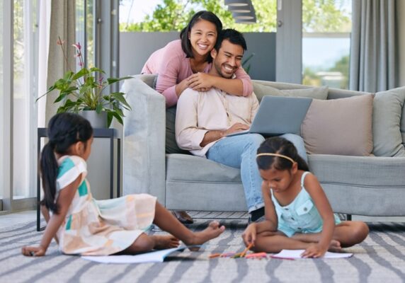 couple and two kids lounging happily in the living room during summer