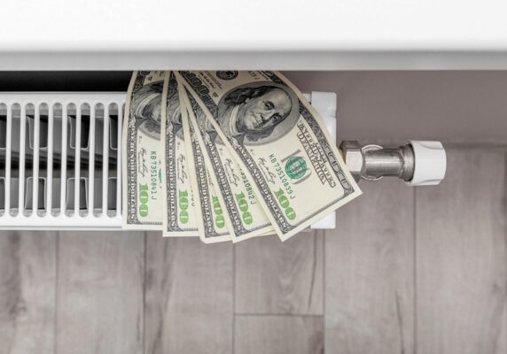 dollar bills on top of heating oil radiator depicting Stretch Your Heating Oil Supply
