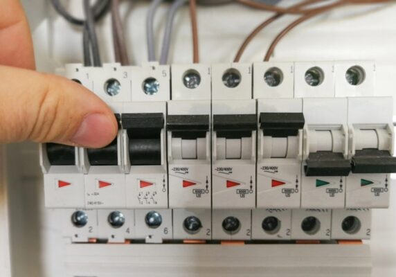 homeowner switching circuit breakers in an electrical panel