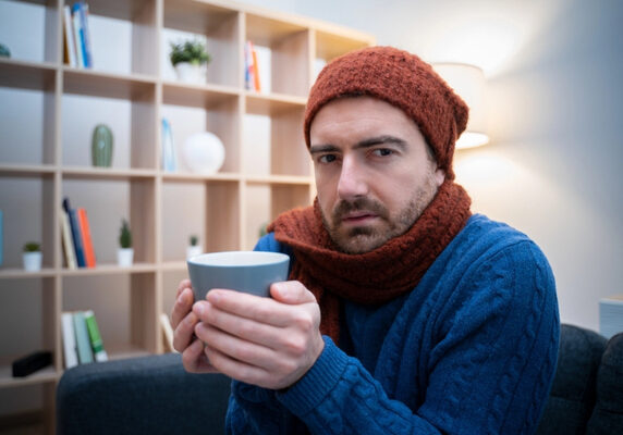 man feeling very cold at home due to furnace failure