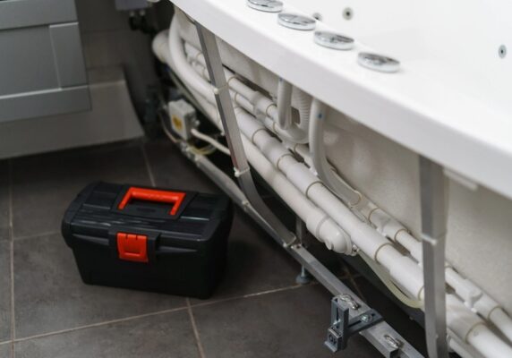 toolbox near pipe system of a bathtub
