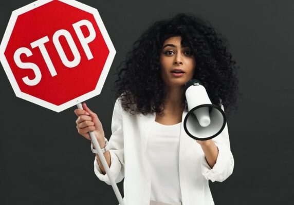 woman holding a top sign and a megaphone depicting Heating Oil Myths